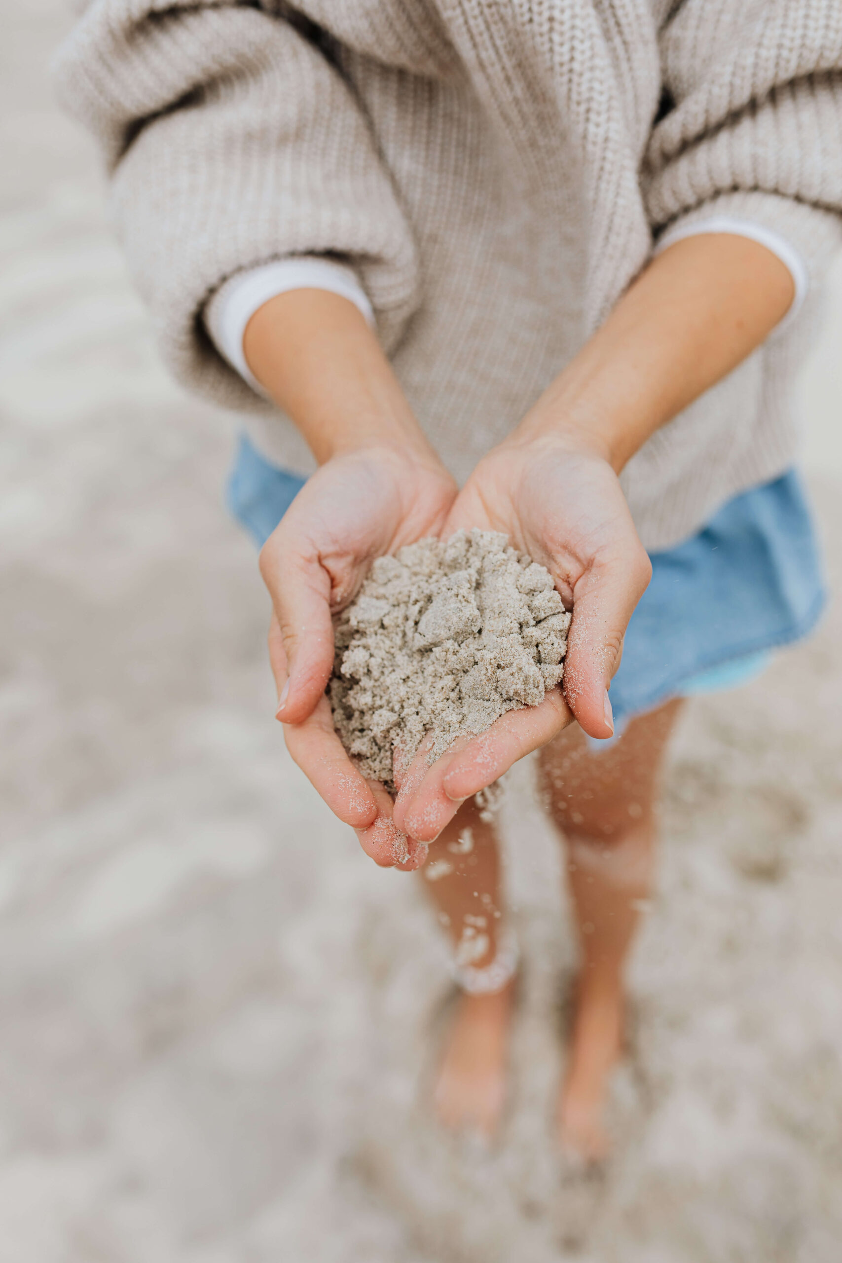 a-young-woman-on-the-beach-is-holding-sand